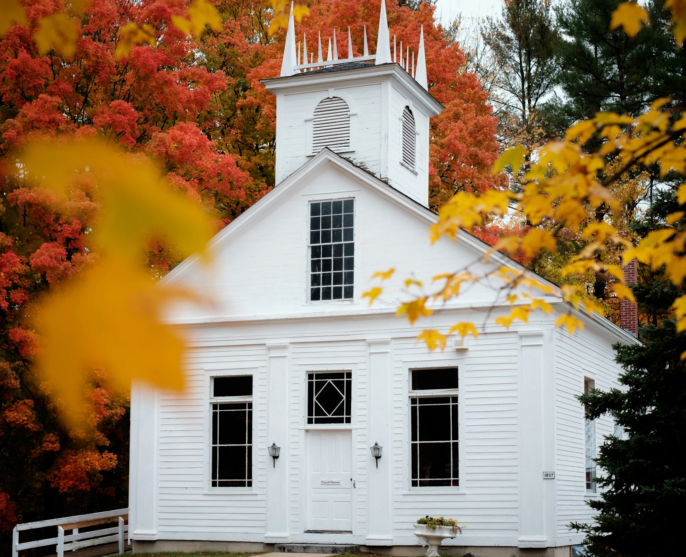 The Grace Hill church building framed by autumn trees on a clear day.