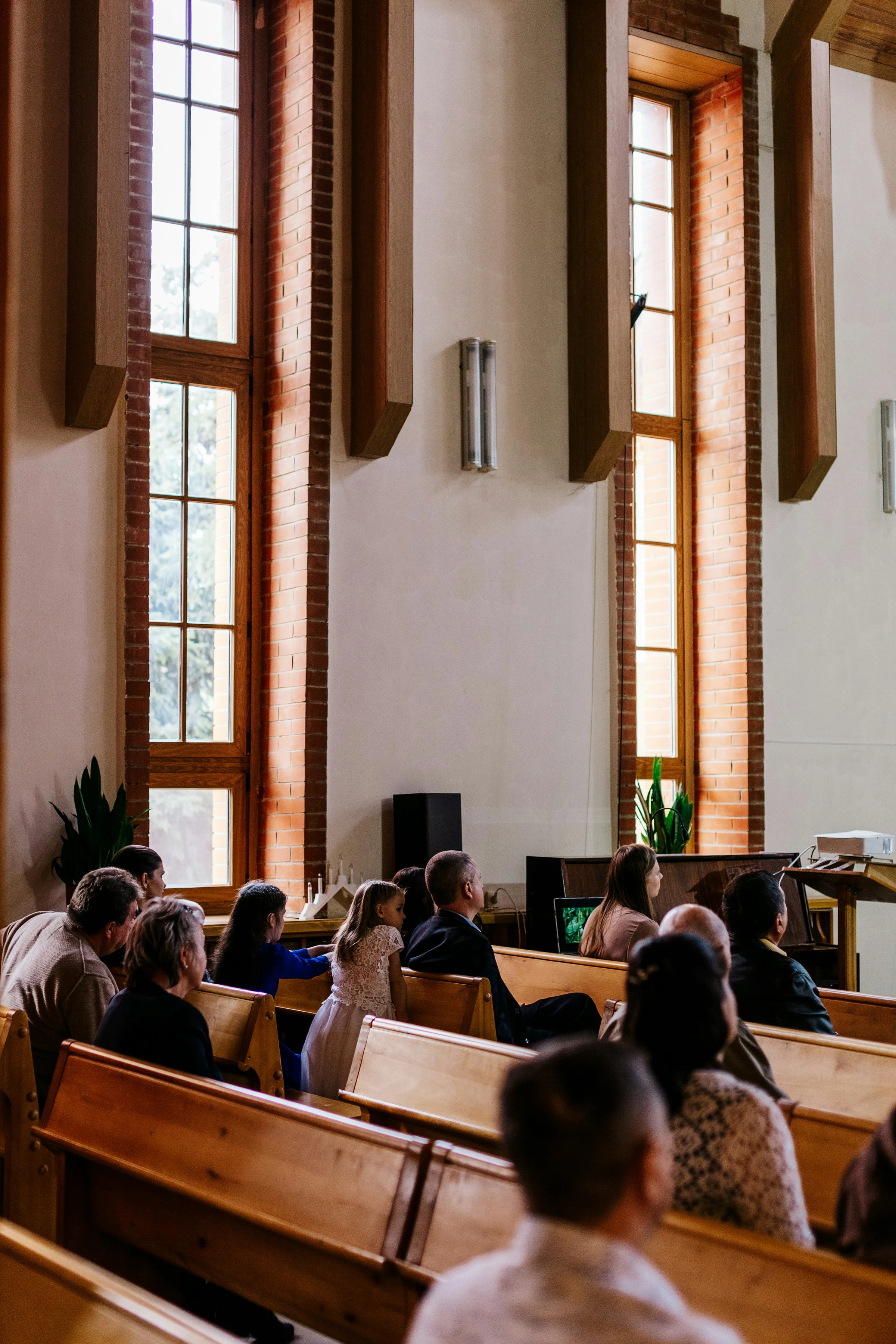 A small congregation seated in wooden pews during a Sunday service.