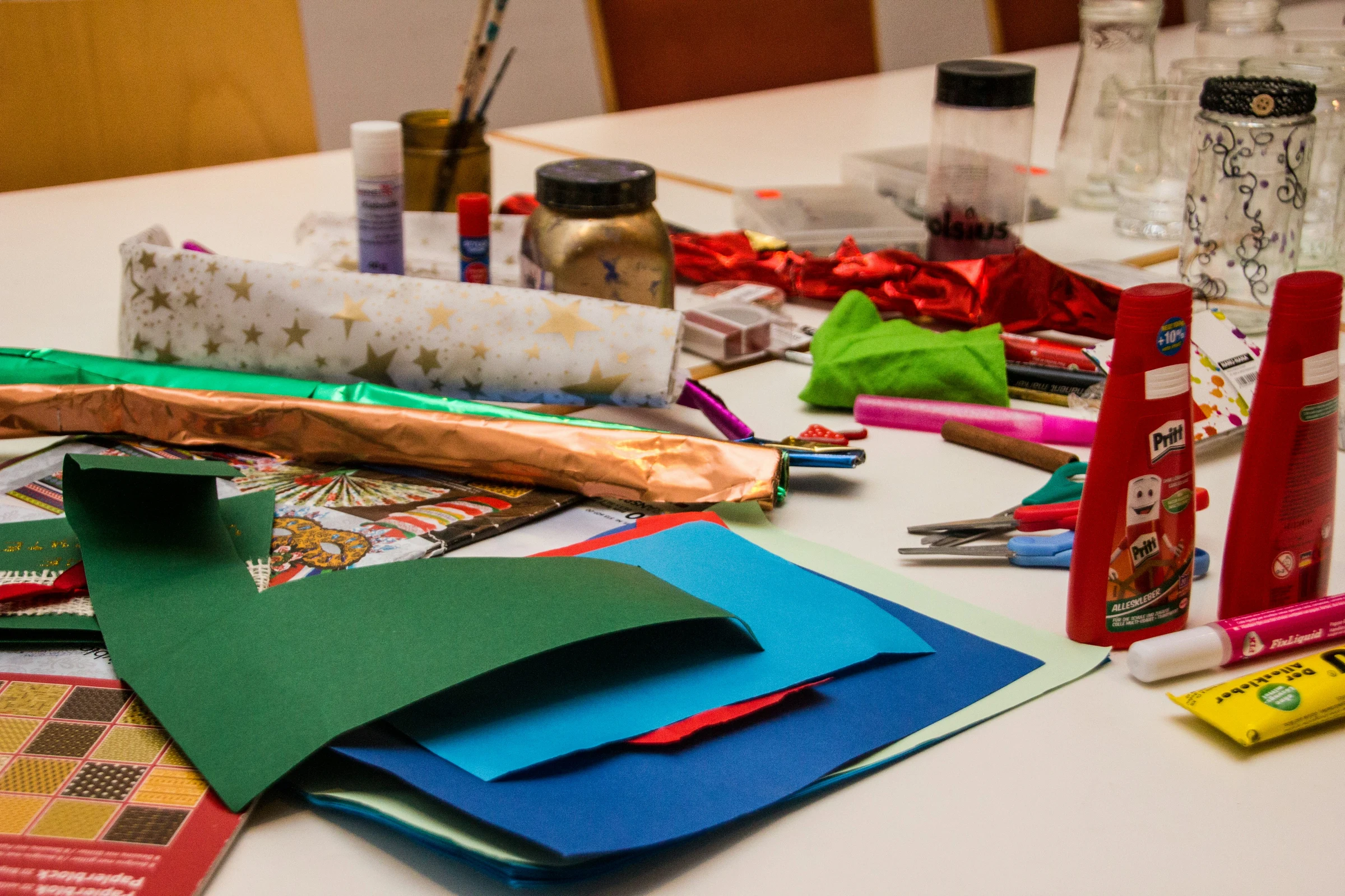 A children's craft table — paper, crayons, scissors arranged before a Sunday-school session.