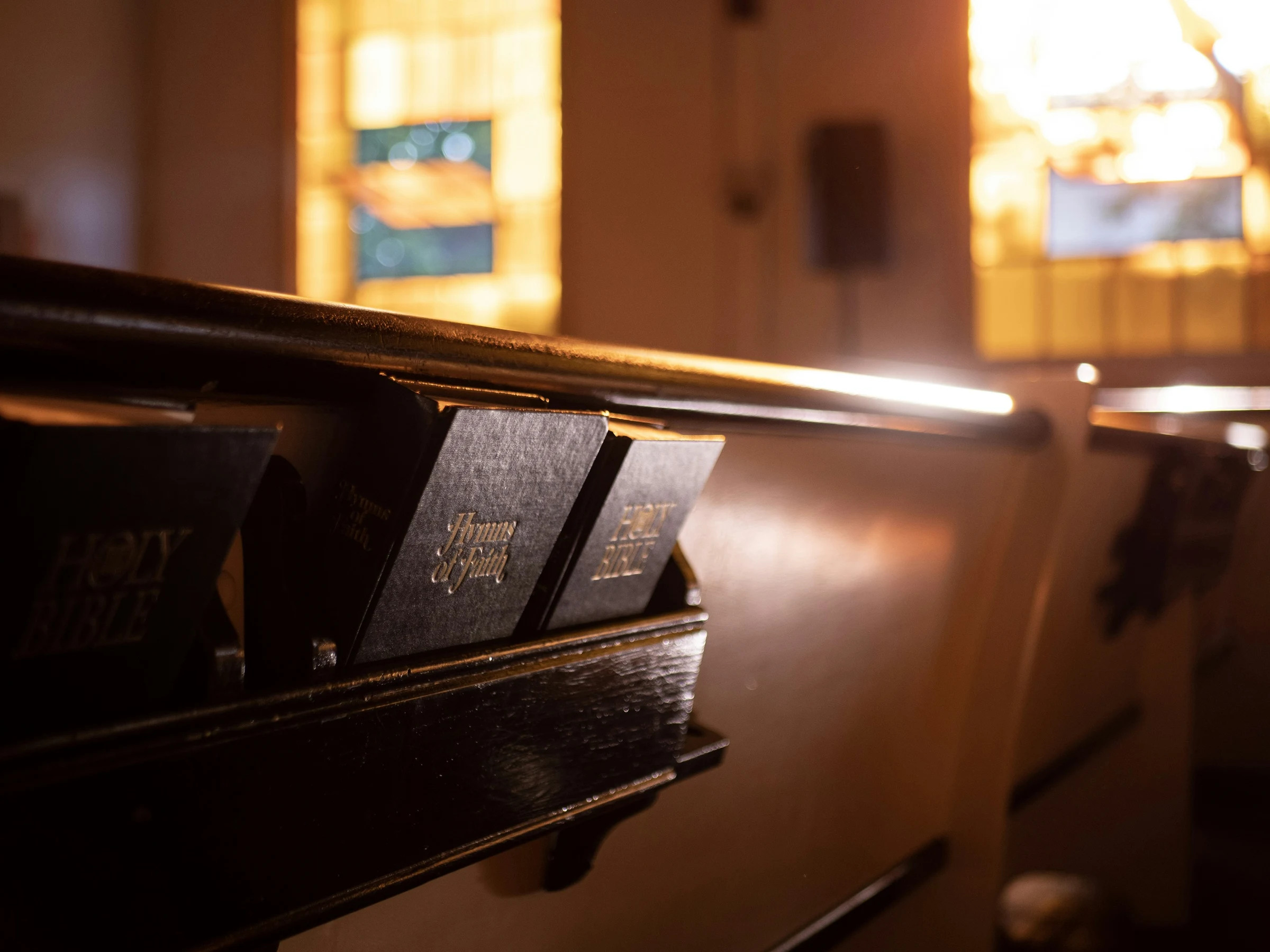 A quiet detail of a brown wooden church pew — contemplative and still.