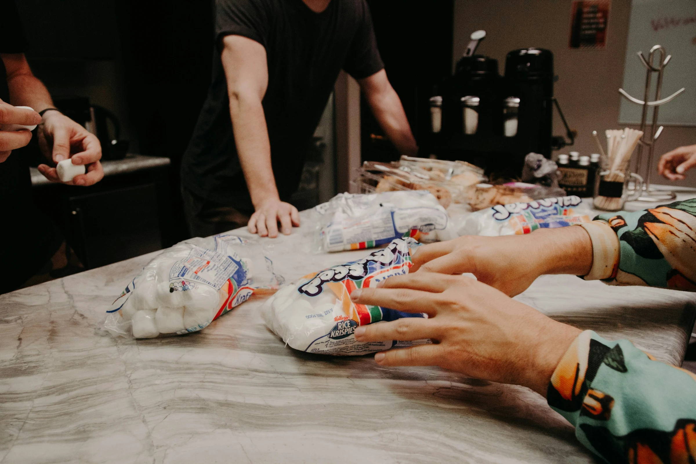 Hands packing labelled food parcels for the monthly community foodbank.