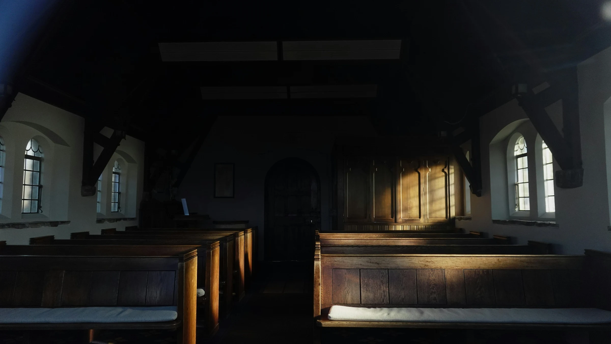 Grace Hill sanctuary — empty wooden pews with soft daylight through the tall windows.