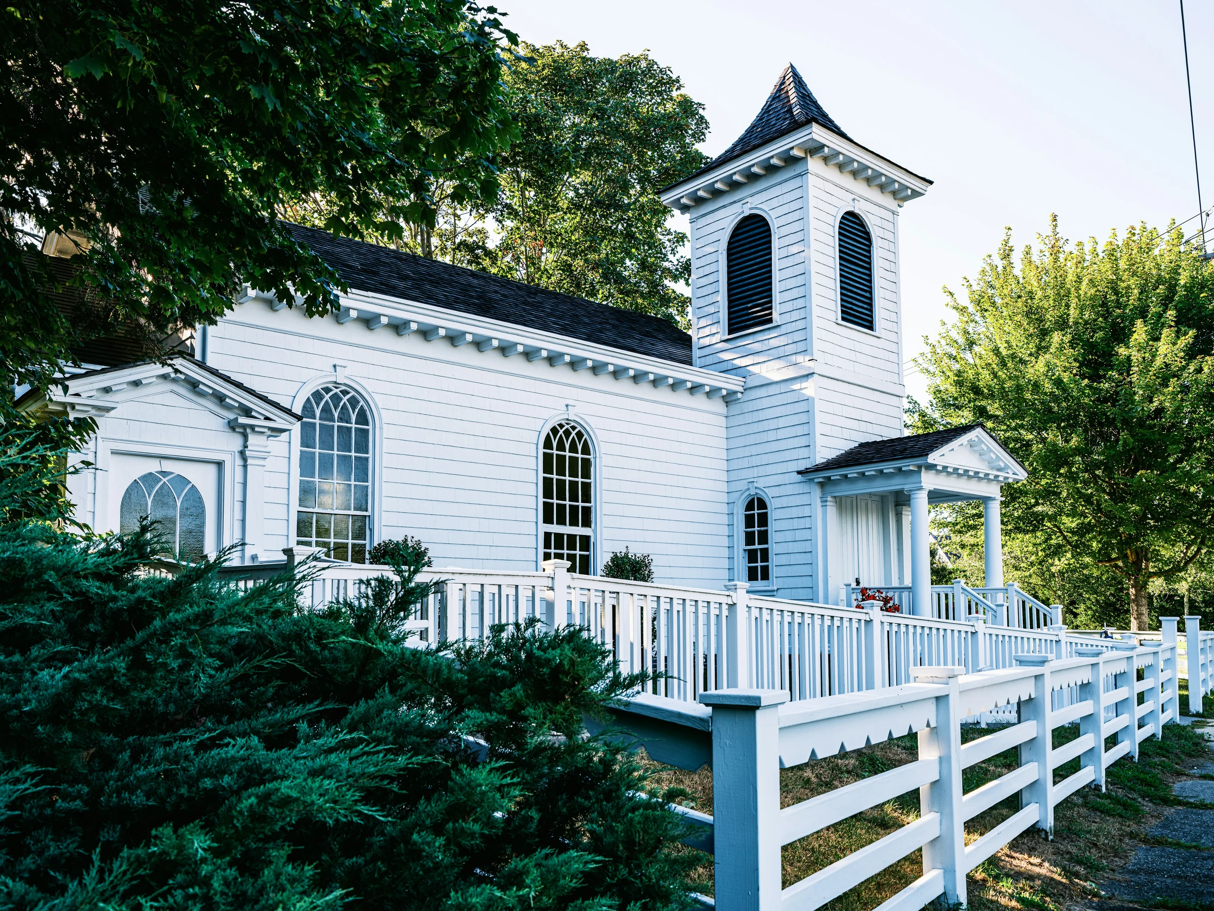 A small historic white clapboard church with a slim steeple — the kind of building Grace Hill is.